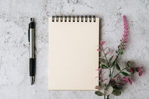 photo top view of beautiful plant leaves with notebook and pen