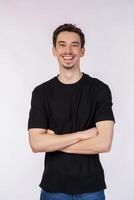 Portrait of young handsome man wearing black t-shirt, standing with crossed arms with isolated on studio white background photo
