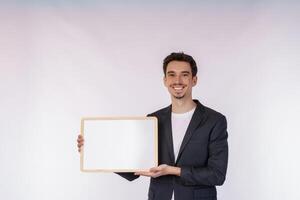 Portrait of happy businessman showing blank signboard on isolated white background photo