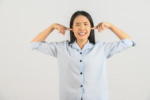 Portrait of Young asian woman in blue shirt plugged her ears with her fingers isolated on white background photo