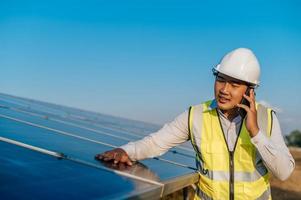 Young engineer use smartphone while working at solar farm