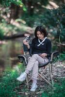 una mujer bonita joven usa una cámara para tomar fotos en un parque natural