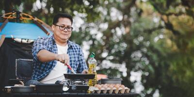 Portrait of Asian traveler man glasses pork steak frying photo