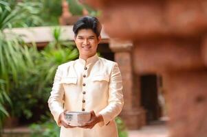 Portrait handsome man in Songkran festival with water bowl photo