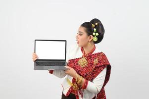 Portrait of Beautiful Thai Woman in Traditional Clothing Posing with laptop computer photo