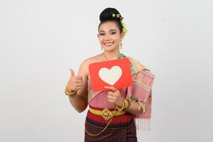 Young beautiful woman in Thai northeastern costume with card in heart symbol photo