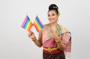 Portrait of Young woman in Thai Northeastern Traditional Clothing holding rainbow flag photo