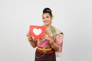 joven hermosa mujer en tailandés del nordeste disfraz con tarjeta en corazón símbolo foto