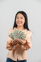 Portrait of a cheerful young woman holding money banknotes and celebrating isolated over white background photo