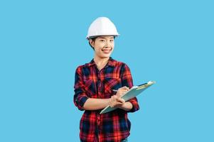 Young asian engineer female use pen to check list on clipboard posture photo