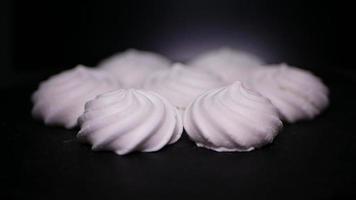 bonbons Meringue tourbillonne sur une noir Contexte video