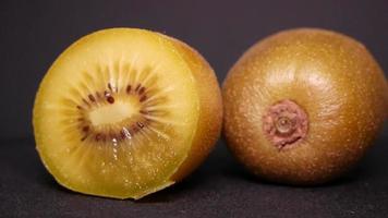 Golden kiwi on a black background rotates video