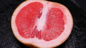 Ripe grapefruit on a black background rotates video