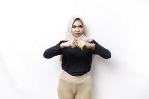 Beautiful Asian Muslim woman wearing a hijab with hand gesture pose rejection or prohibition with copy space photo