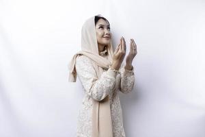 Religious beautiful Asian Muslim girl wearing a headscarf praying to God. photo