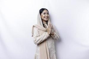 Portrait of a young beautiful Asian Muslim woman wearing a hijab gesturing Eid Mubarak greeting photo