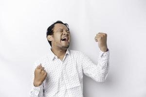 A young Asian man with a happy successful expression wearing white shirt isolated by white background photo