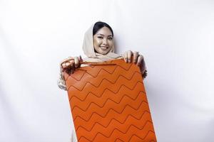 Portrait Asian Muslim woman happy beautiful young standing excited holding a shopping bag, studio shot isolated on white background photo