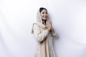 Portrait of a young beautiful Asian Muslim woman wearing a hijab gesturing Eid Mubarak greeting photo