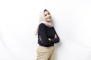 Portrait of a confident smiling Asian Muslim woman wearing hijab standing with arms folded and looking at the camera isolated over white background photo