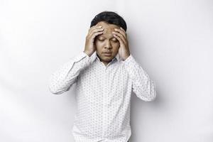 A portrait of an Asian man wearing a white shirt isolated by white background looks depressed photo