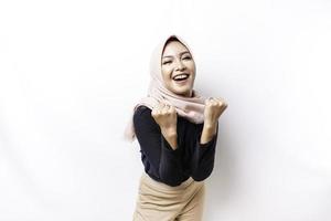 A young Asian Muslim woman with a happy successful expression wearing a hijab isolated by white background photo