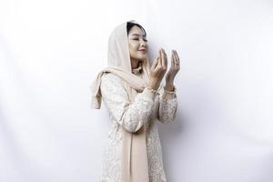 Religious beautiful Asian Muslim girl wearing a headscarf praying to God. photo