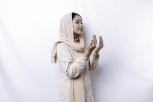 Religious beautiful Asian Muslim girl wearing a headscarf praying to God. photo