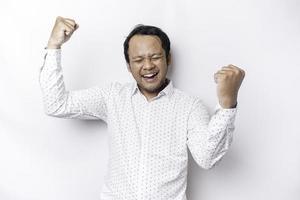 A young Asian man with a happy successful expression wearing white shirt isolated by white background photo