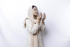 Religious beautiful Asian Muslim girl wearing a headscarf praying to God. photo