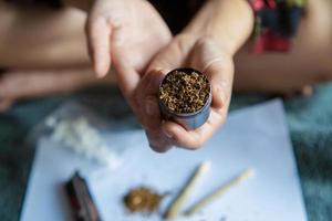 women holding a grinder with marijuana weed against in the room ,Drugs narcotic or Medical marijuana concept. Legal cannabis photo