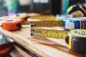 cinta medida o medición cinta con de medida lineal marcas y carpintería mano herramientas en de madera escritorio , bricolaje fabricante y carpintería concepto. selectivo atención foto