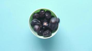 Slow motion of dropping fresh date fruit in a bowl on table video