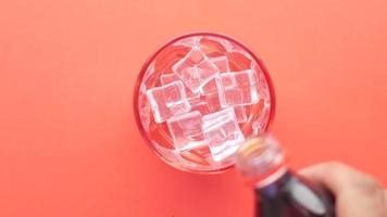 torrencial suave bebidas en un vaso con hielo cubo . video