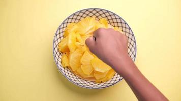 Slice of pineapple in bowl on yellow background . video