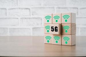 Global communication network concept, Wooden cubes with 5G and wifi icon on wooden desk, Worldwide business, high-speed mobile Internet, new generation networks. Mixed media. photo