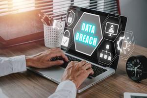 Data Breach concept, Person hand typing keyboard on office desk with data breach icon on virtual screen, Cyber security data protection business technology privacy. photo