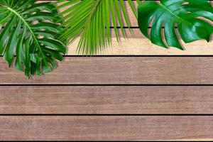 Green leaves pattern for nature concept,tropical leaf on brown wood background photo