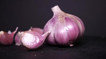 Ripe garlic close-up on a black background video