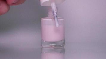 Gently pink nail polish on a white background video