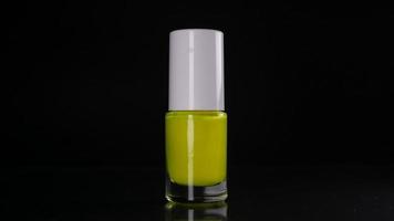 Yellow neon nail polish on black background video