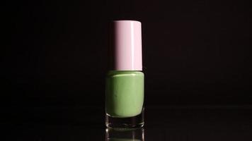 Green neon nail polish on black background video