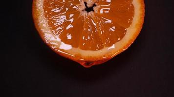 Liquid honey flows down slowly from an orange ring on a black background video