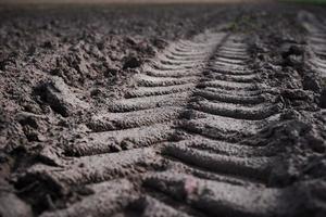 Trail track of tractor on plowed field photo