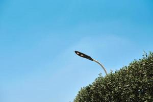 Energy saving led lamp in street lamp against blue sky, closeup photo