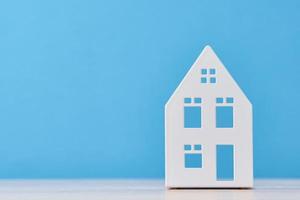 Figure of toy house on a blue background with copy space photo