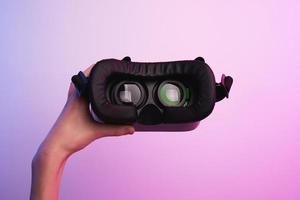 virtual realidad lentes en mano en vistoso antecedentes. futuro tecnología foto