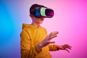 chico con virtual realidad lentes en vistoso antecedentes. futuro tecnología foto