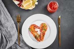 Two shrimps in shape of heart on the plate, top view. Love concept photo