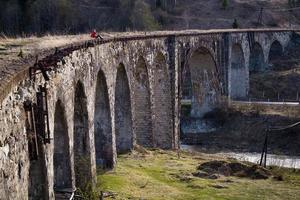 Woman sitting on shabby old bridge landscape photo